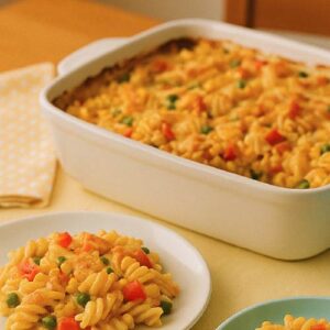 Schneller Nudelauflauf mit Ei, Paprika und Mais, goldbraun überbacken in einer weißen Auflaufform.